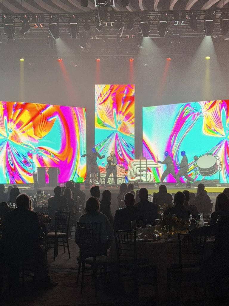 Blue Man Group performing against three LED walls